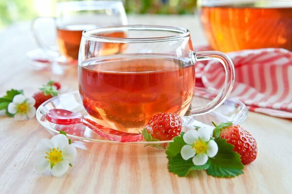 Tea with strawberries in a transparent cup