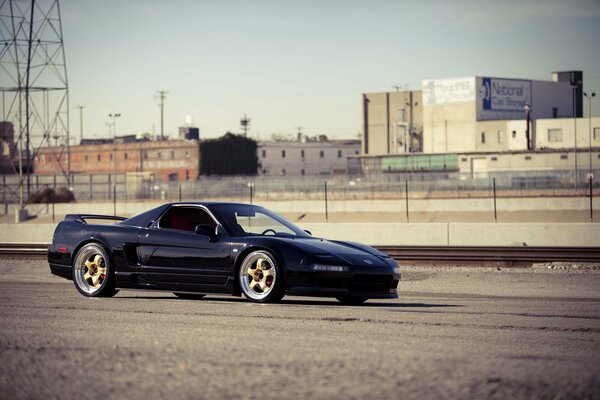 Black Acura on the background of city buildings