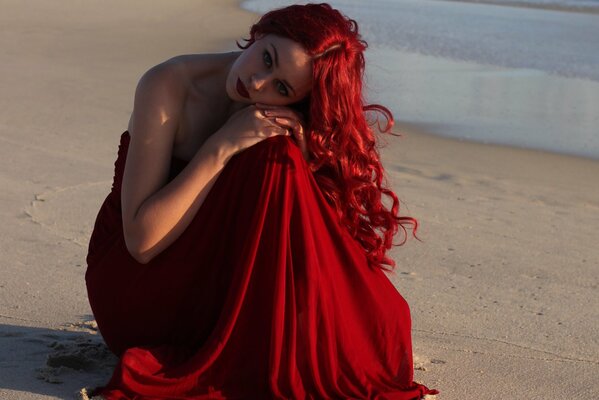 A girl with fiery red hair on the beach