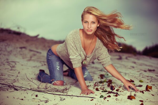 Ragazza in jeans fotografata sulla sabbia