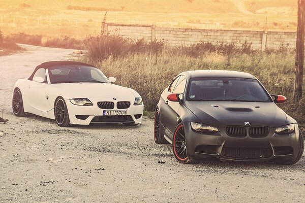 A white BMW overtakes a black one on the road