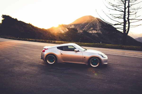 Nissan rides down the slope against the sunset