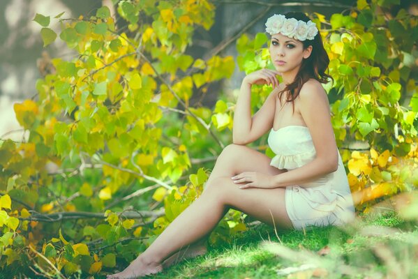 Chica en una corona en el fondo de la naturaleza