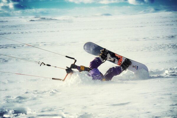 The athlete is a windsurfer maneuvering in the snow