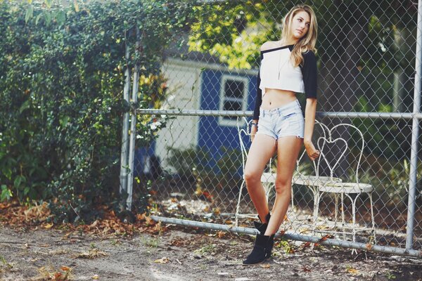 The girl poses at the fence