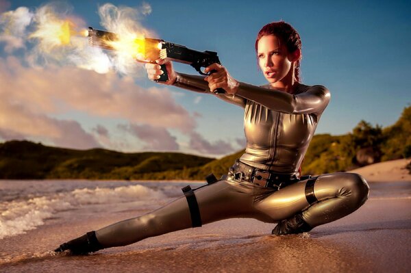 A woman with pistols in her hands against the background of sea water and sand