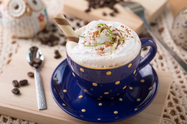 Cappuccino en una taza azul en una tabla de madera