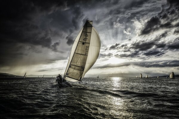 Sailboat in the gray sea under the clouds