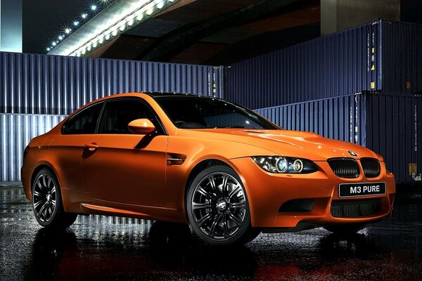 Bmw naranja contra la valla azul