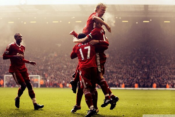 Football players celebrate a goal on the field