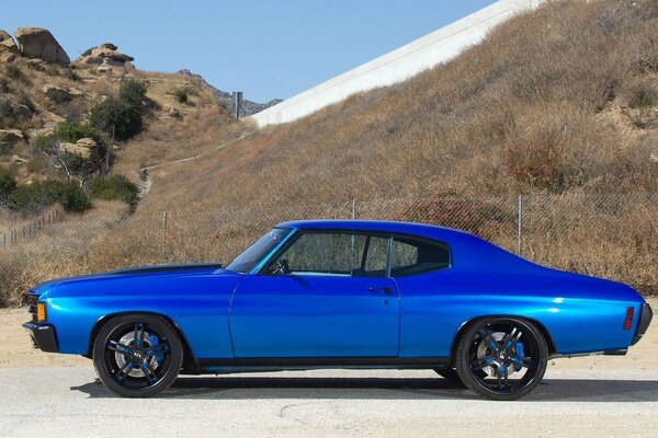 Blue chevrolet on the road in the mountains