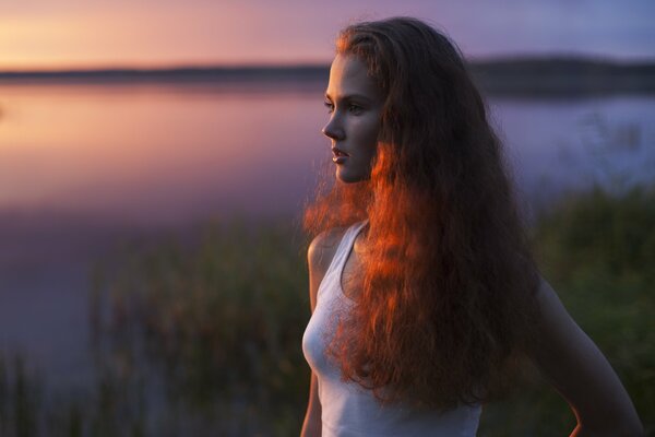 Ragazza dai Capelli rossi vicino al lago della sera