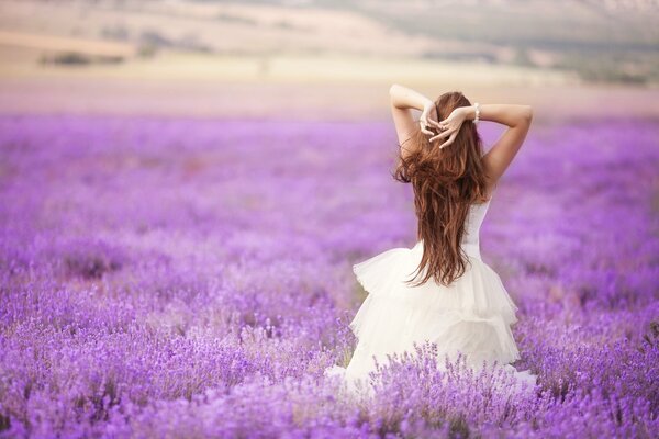 A girl in a white dress poses in a field for a family album