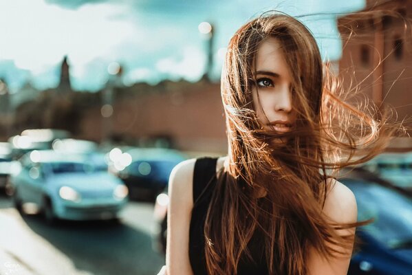 Chica con el pelo largo en el fondo de la ciudad