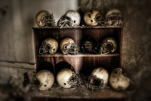 Old worn football helmets on the shelf