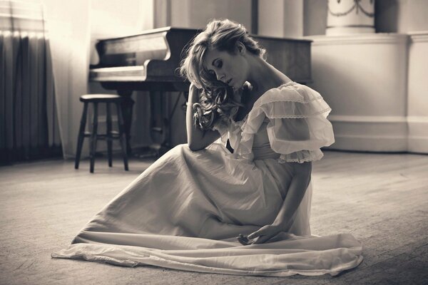 A girl in a dress is sitting at the piano