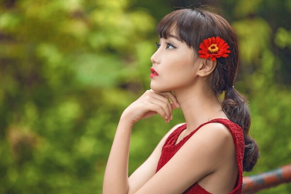 Chica asiática con una flor en el pelo