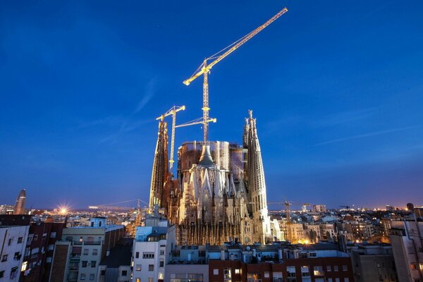 Barcelona is a night city with illuminated construction cranes