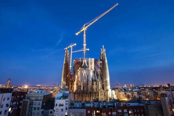 Barcelona ciudad nocturna con grúas de construcción iluminadas