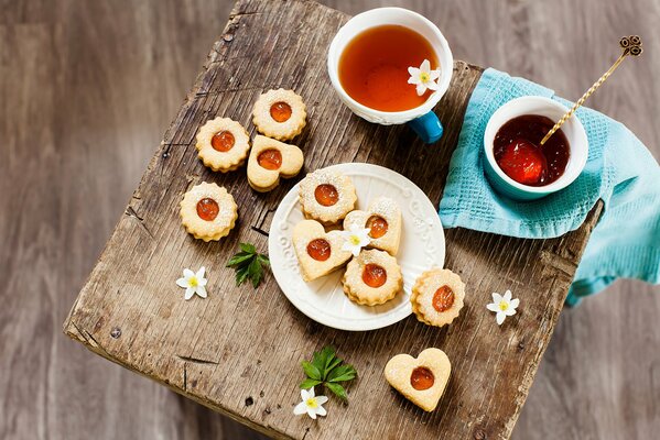 Dessertkekse mit schwarzem Tee und Blumen