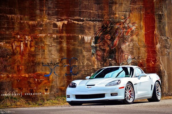 Blanco Chevrolet Corvette C6 en el fondo de la pared grunge con graffiti