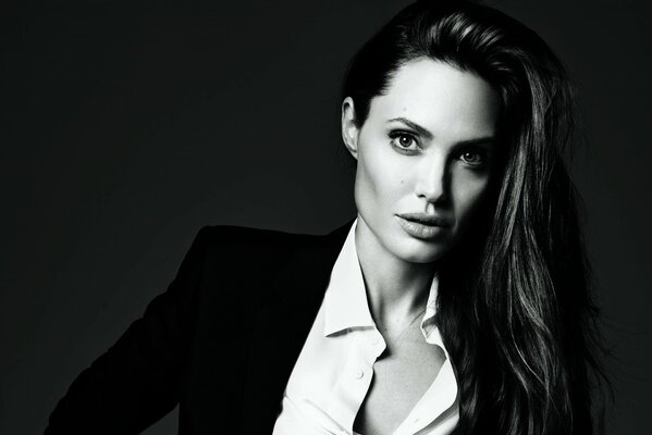 Czarno-białe zdjęcie Angeliny Jolie w czarnym garniturze i białej koszuli