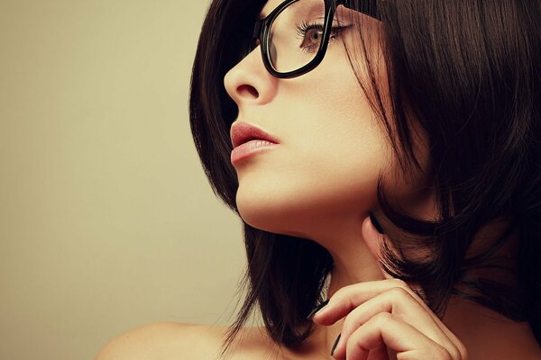 The girl is photographed in profile, wearing glasses with her hair down to her shoulders