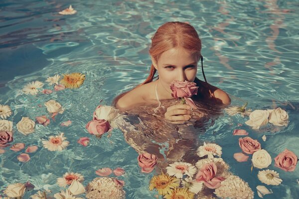 Mädchen mit Blumen in den Händen im Wasser