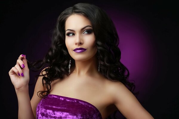 The brbnetka model with purple lips and in a purple dress looks away