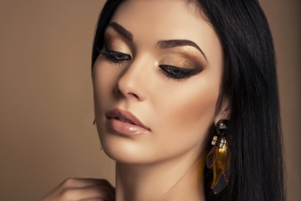 Modelka z makijażem w złotych odcieniach