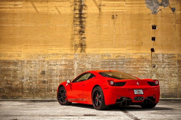 Ferrari 458 Italia rouge sur fond de vieux mur jaune