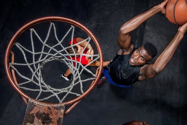 Der Spieler wirft den Ball in den Basketballkorb