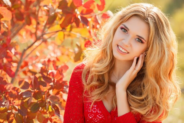 Retrato de otoño de una chica rubia con una chaqueta roja
