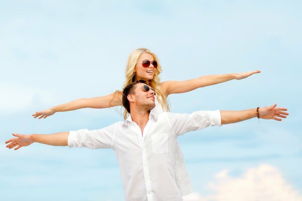 A happy married couple is photographed against the sky