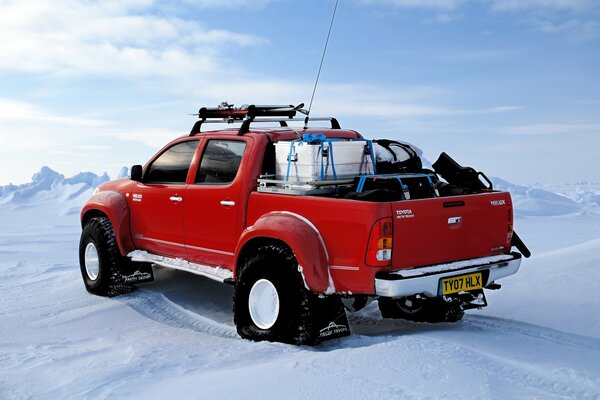 Red toyota at the North Pole in winter in the middle of snow