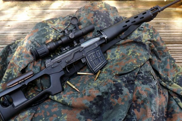 Sniper rifle with a sight on a camouflage jacket