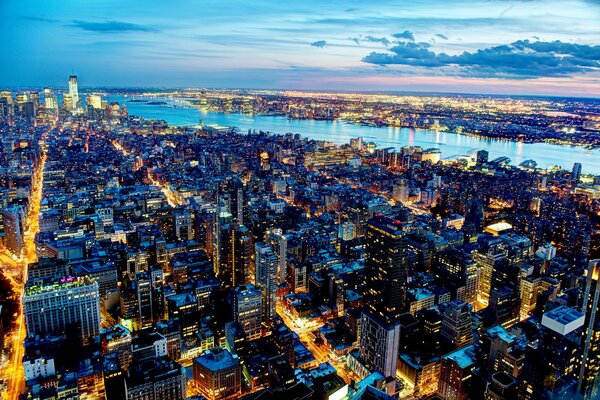 Ciudad de la noche de nueva York con rascacielos río luces y hermoso cielo