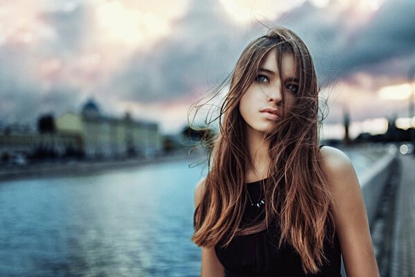 Portrait of a girl on the background of a river