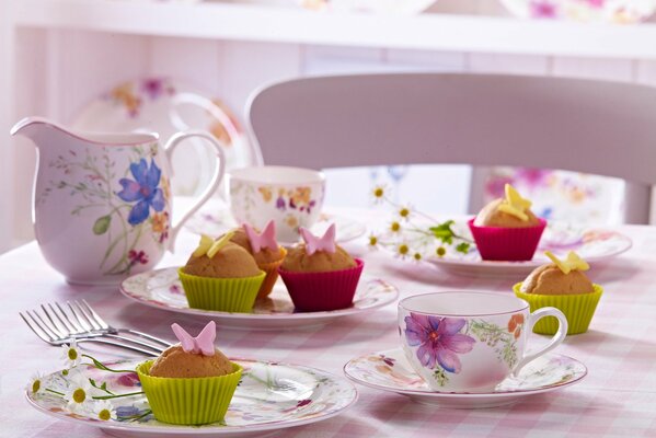 Leckere Muffins auf Tellern und Tee warten auf Sie zum Nachtisch