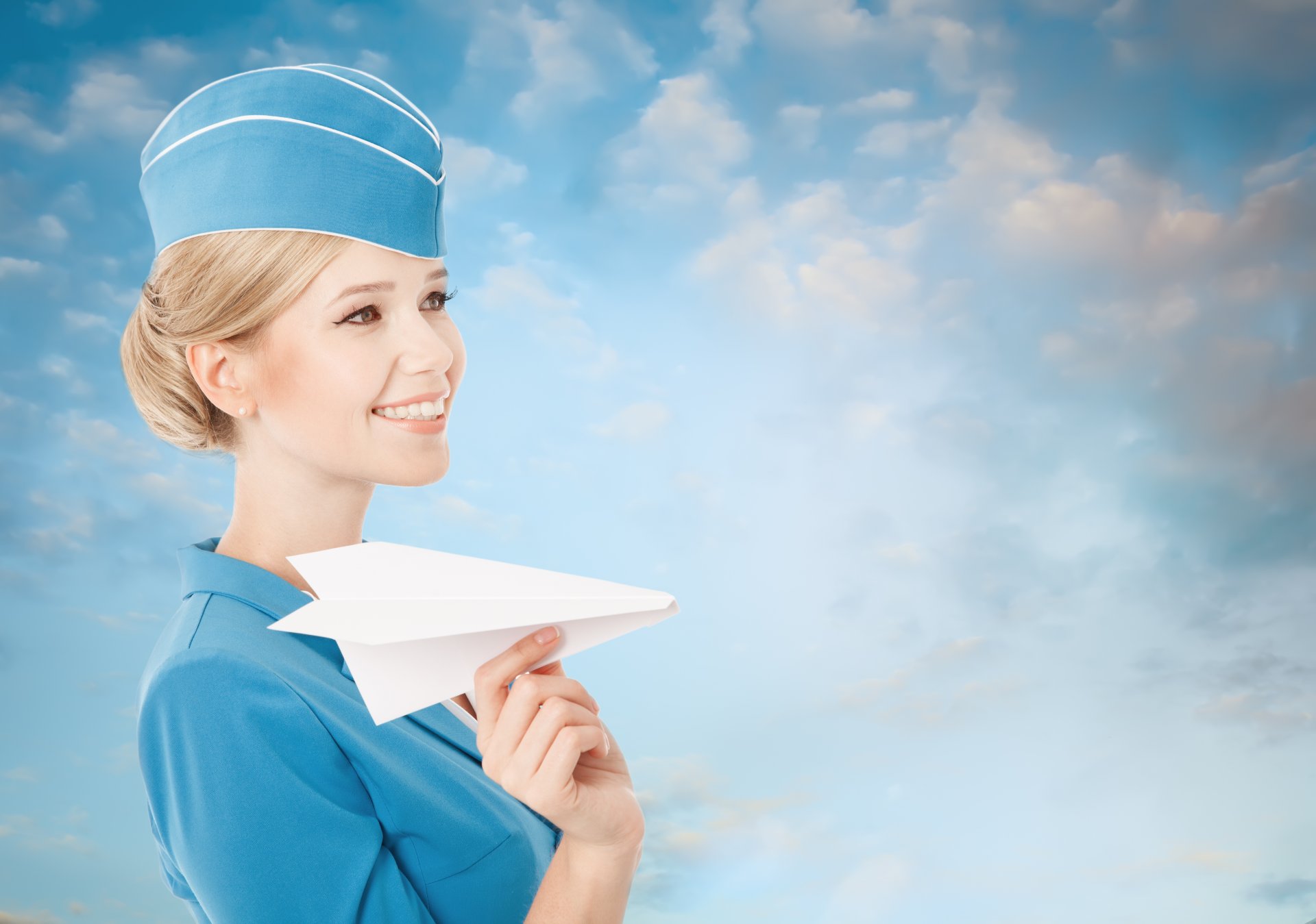 fille blonde hôtesse de l air sourire avion en papier uniforme