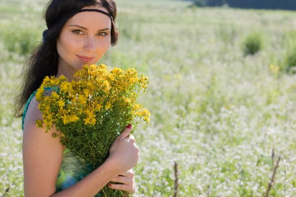 Maria Shvets in un campo con un mazzo di fiori