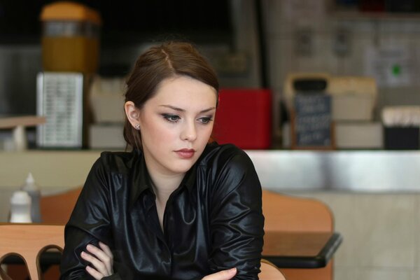 A girl with a thoughtful look in a cafe