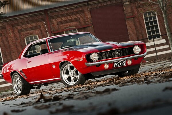 Red car on the background of a brick house