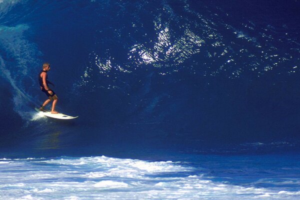 A blue wave in the ocean and a man