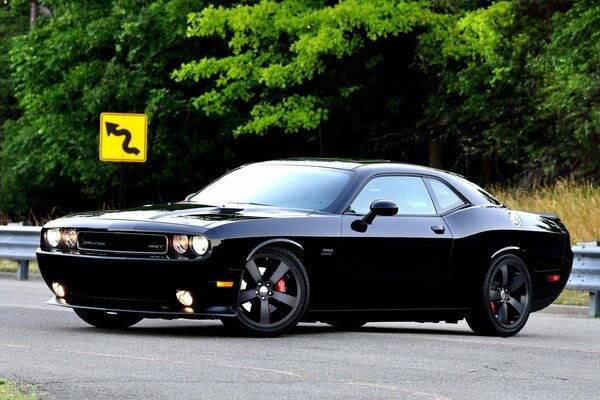 Côté dodge srt8 sur la route avec des arbres