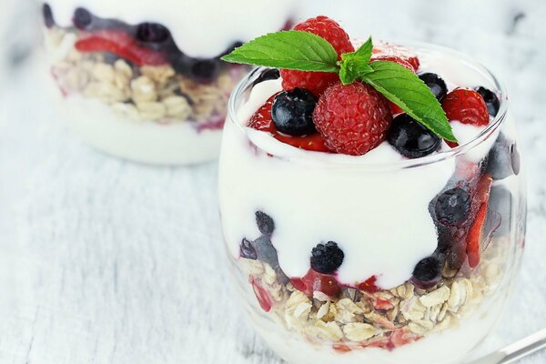 Délicieux dessert dans un verre de muesli, de crème glacée et de baies