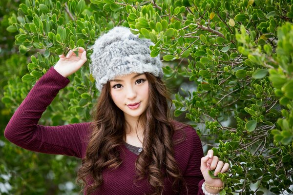 Asian model on the background of tree leaves