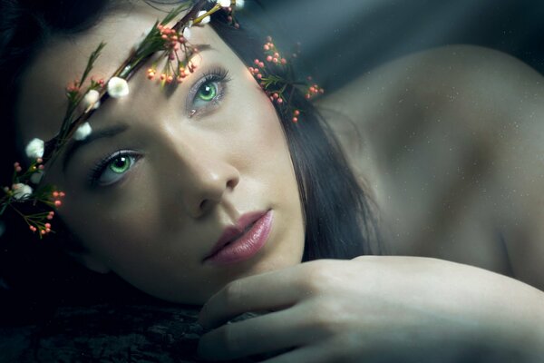 Portrait of a green-eyed girl with a shimmering wreath