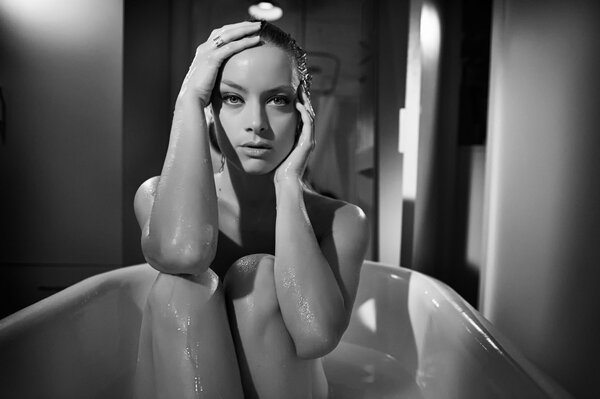 Черно-белое фото девушки сидящей в ванной