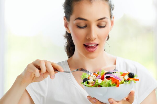 A girl eats a vegetable salad